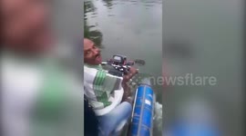 A Man riding his own made boat-bike created from scratch on a lake