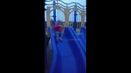 Ellie going down the slide with mom's encouragement