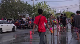 Thai people celebrating Songkran festival, by splashing each other with water in the streets.