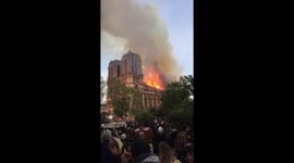 Crowds watch rooftop Notre Dame fire in Paris.