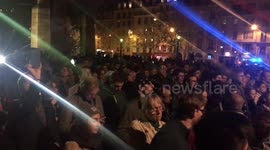 Parisians gather and sing hymns on the Tournelle Bridge opposite Notre Dame