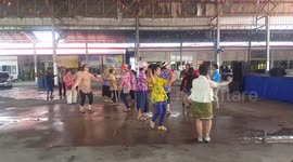 Senior Thai ladies celebrate Songkran festival by dancing in colorful traditional dress.