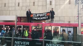 Environmental protesters stand on top of train in London's Canary Wharf
