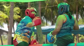 Thai youngsters engage in boxing match whilst balancing on pole above pool