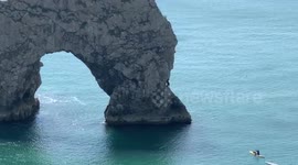 Surfers ignore safety signs to jump off Dorset's Durdle Door during Easter Holiday sunshine