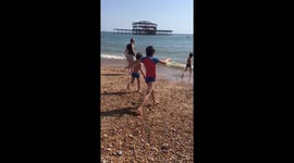 Easter 2019 heatwave : children take a dip in the icy sea on Brighton beach and are shocked and surprised at how freezing it is!