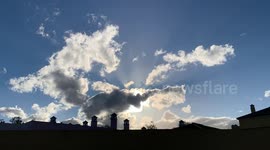 time lapse spanish roof tops with sun behind clouds