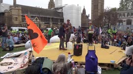 Climate change campaigners are instructed on how to hand in their letters to MPs by a speaker in Parliament Square on 23 April 2019