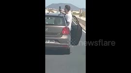 Reckless passenger leans from car door to take selfie on busy road in the Canary Islands