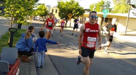 young boy gets a high five from marathon runner