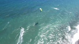 kite surfer surfing in teh ocean filmed from drone