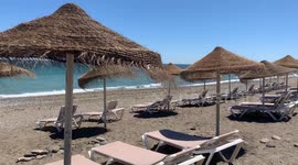 empty summer beach with sunbeds and parasols beautiful summer day with a slight breeze
