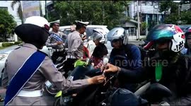 Indonesian police remind road users to take care by handing out flowers