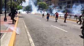 Anti-Maduro protesters run for cover as riot police fires tear gas in the streets of Caracas
