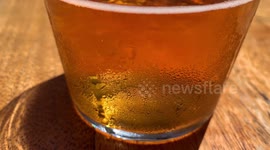 Slow pan up beer glass in restaurant on a sunny day