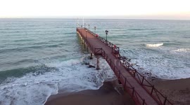 pier in ocean with man thinking about life - summer vacation shot from drone