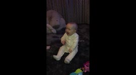 Baby laughs so hard she falls over backwards - very funny!!!