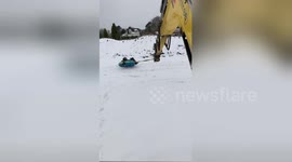 Newsflare Edit - Workers take a spin in the snow with aid of excavator
