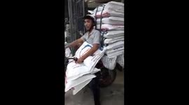 The man carries many heavy bags of hundreds of kilograms by motorbike