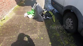 Pile of rubbish dumped on pavement lying on tree