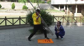 Chinese man uses giant chopsticks to feed fruit to woman