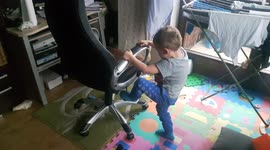 3 years old boy shows amazing stunt getting through the swivel chair, laughs and pets dog
