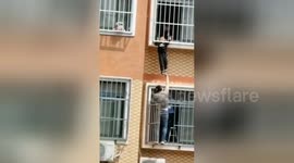 Heroic Chinese man holds up boy hanging from seventh-floor window until help arrives