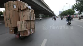 Strange moment a motorcyclist is carrying huge cargo boxes, moving very fast and dangerous on the street