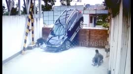 SUV driving off wall narrowly misses worker napping underneath