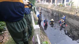 Sewage workers dredge stinking black waste out of canal in Vietnam