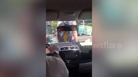 Angry tourist late for taxi booking sits on bonnet to stop car from leaving without him