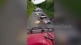 Motorist forced to slalom around mounds of fly-tipped rubbish on country lane in Wales