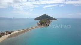 2.7K Aerial View along Mid - South Molle Island (with Helicopter parked on Beach)