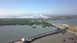Drone Aerial View of the Traffic at the Ocean Toll Road Entry and Burning Waste Dump in Bali Indonesia