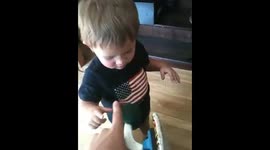 Cute baby gets frustrated trying to spin skateboard wheel