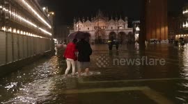 Tourists forced to wade as unusually high tide floods Venice