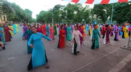 Hundreds of people wear long dress in many colors dancing on the street. Looking at these costumes is very beautiful and strange.
