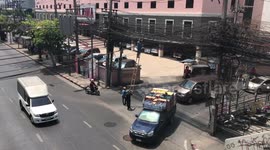 Health And Safety? Workers plant tall ladder In the middle of the road in Bangkok, Thailand