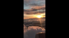 Destination heaven: Plane flies through layers of clouds in serene sunset