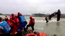 Chinese firefighters rescue workers trapped on flooded digger