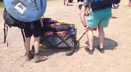 Festival attendees struggle with trolley that breaks under weight of their possessions