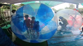 Children playing inside giant floating transparent balls floating on the lake! Walking on water