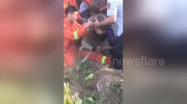 Firefighter hangs upside-down to rescue toddler trapped down deep well in China