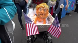 Trump protest in Parliament Square - participant with a paper mâché baby Trump in a pram