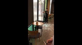 Coffee shop customers stunned as powerful storm smashes glass door in Thailand
