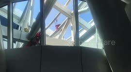 Men hang from rafters cleaning