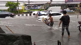 Man goes surfing on flooded Thai road after heavy rain