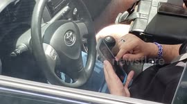 Driver caught texting and driving as viewed nicely from a double decker transit bus