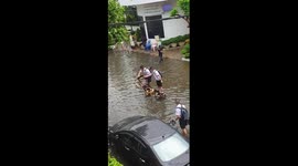 Ingenious schoolboys use three wooden chairs to cross flooded road in Thailand