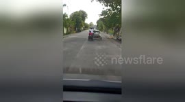 Motorbike with sidecar pulls wheelchair on road in the Philippines